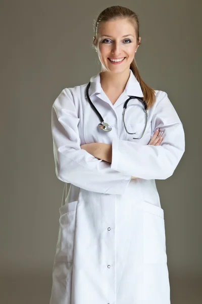 Γυναίκα ιατρός με τη στολή με το στηθοσκόπιο σε ουδέτερο γκρι — Φωτογραφία Αρχείου