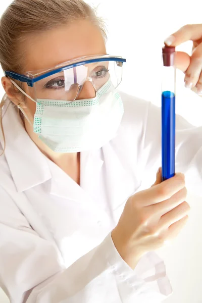 Ізольована вчена жінка в лабораторному пальто з хімічним скляним посудом — стокове фото