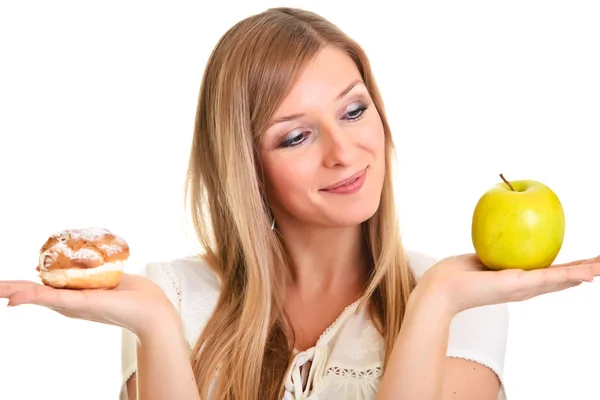 Женщина выбирает яблоко вместо слоеного печенья изолированы на белом — стоковое фото