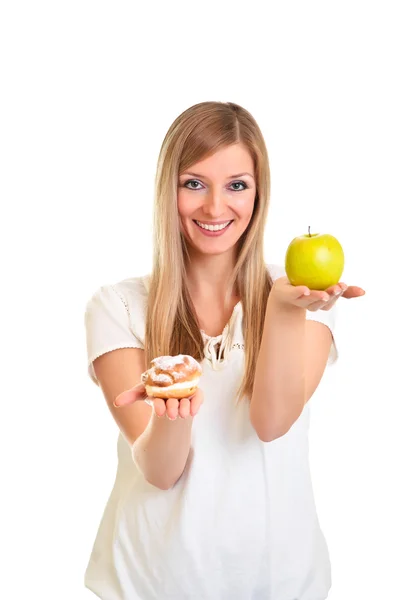 Женщина выбирает яблоко вместо слоеного печенья изолированы на белом — стоковое фото