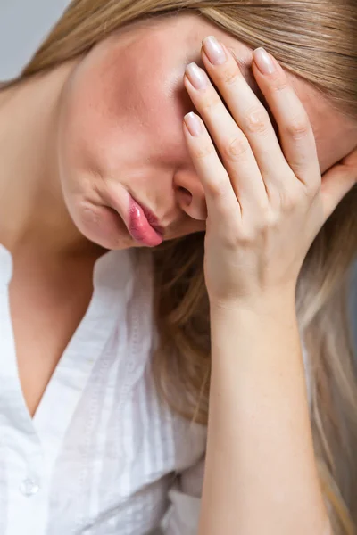 Депрессивная, грустная женщина на нейтральном фоне — стоковое фото