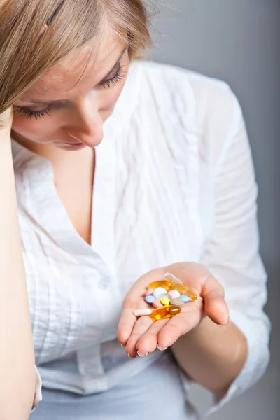 Kobieta trzyma leków na neutralny bg — Zdjęcie stockowe