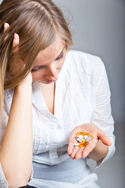 Woman holding pharmaceuticals on neutral bg — Stock Photo, Image