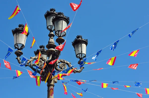 stock image Pole with many flags against blue sky