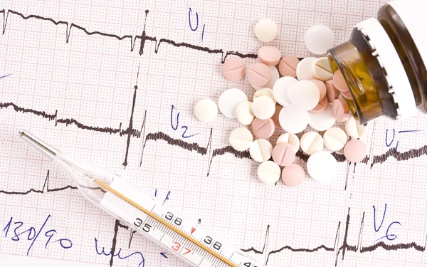 Таблетки на кардіограмі — стокове фото