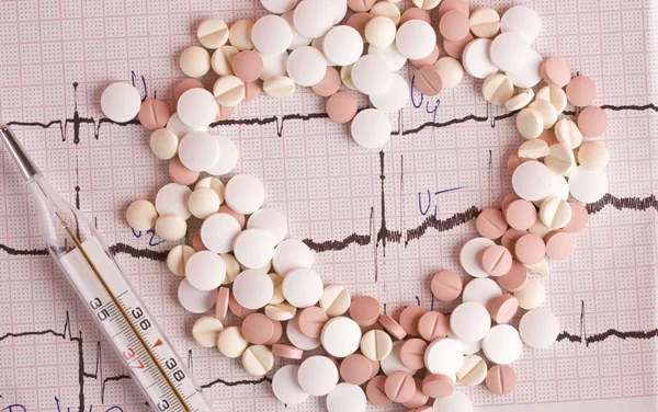Pills on the cardiogram — Stock Photo, Image