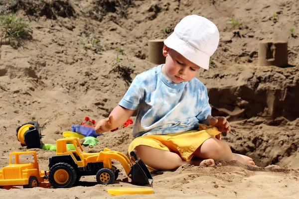 Criança brinca com areia — Fotografia de Stock