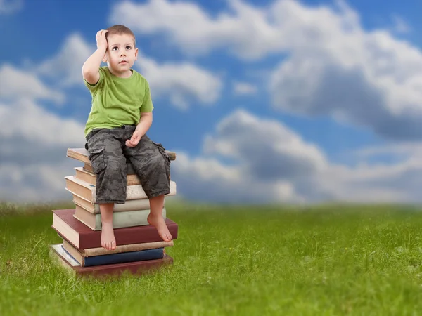 Niño sentado en libros —  Fotos de Stock