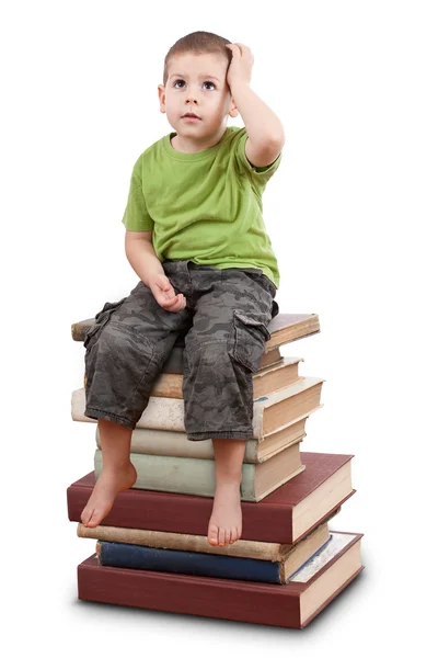 Criança sentada em livros — Fotografia de Stock
