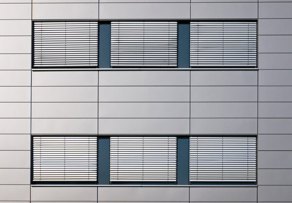 Windows with jalousies of a grey building
