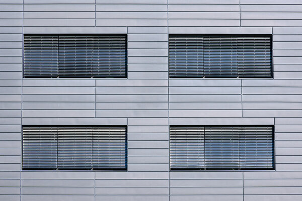 Windows with jalousies of a grey building