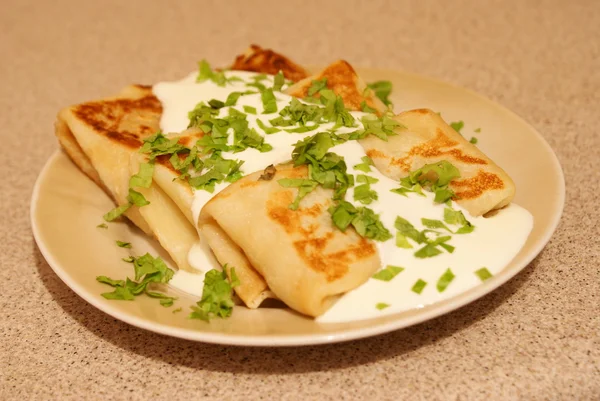 stock image Pancakes with the sour cream, fried, are strewed by small cut greens