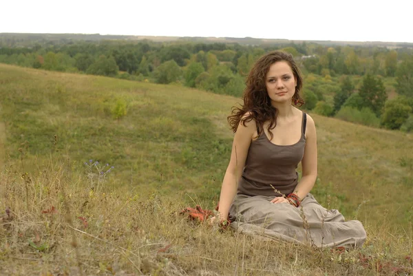 Женщина сидит в поле — стоковое фото