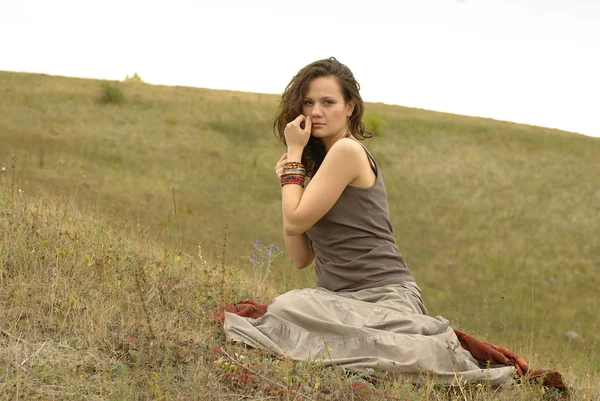 Kvinna sitter i fältet — Stockfoto