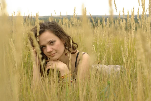Flickan liggande i fältet majs — Stockfoto