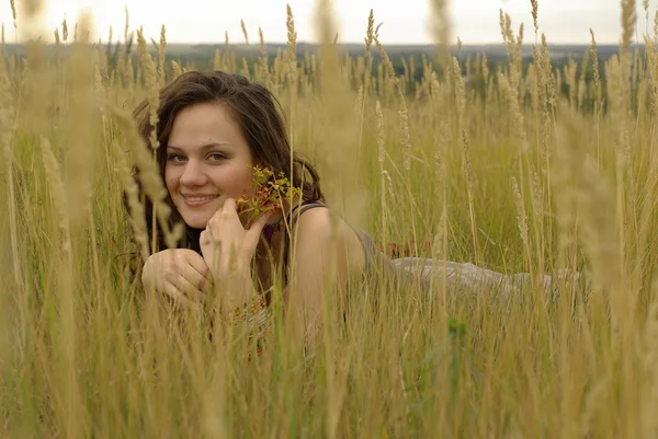 Sorrindo menina deitada no campo — Fotografia de Stock
