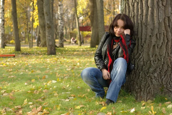 Triste fille assise sous l'arbre — Photo