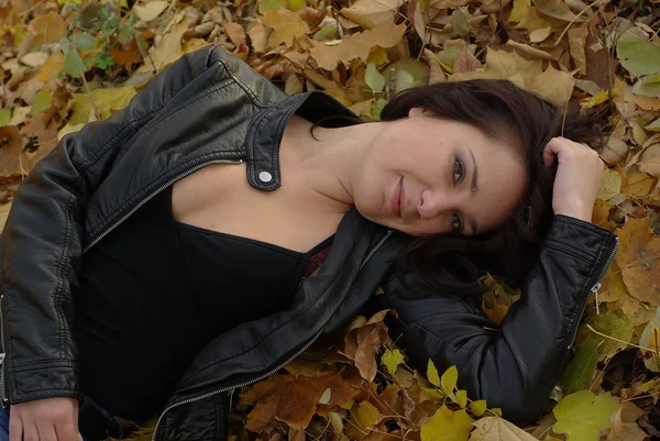 Meisje liggend op de bladeren — Stockfoto