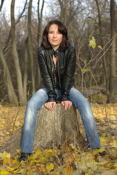 Dziewczyna siedzi na pniu — Zdjęcie stockowe