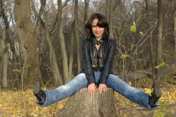 Meisje zit op een boomstronk — Stockfoto