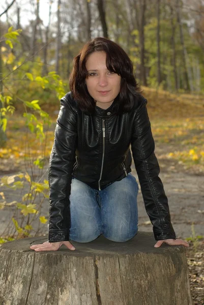 Dziewczyna siedzi na pniu — Zdjęcie stockowe