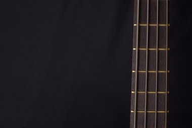 Neck of a bass guitar on the black background clipart