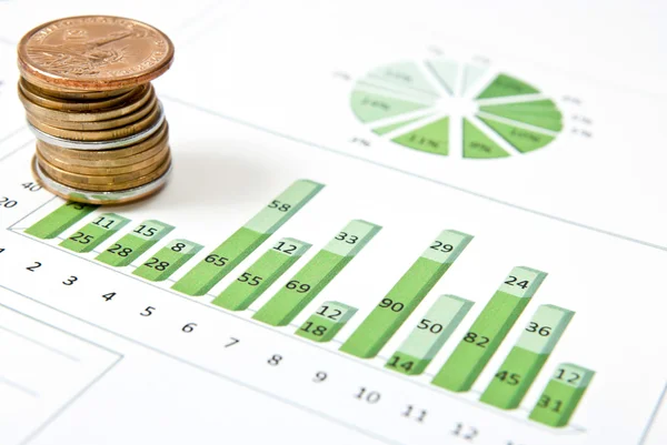 Een stapel van munten en groene grafiek — Stockfoto