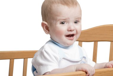 A small child standing in the crib clipart