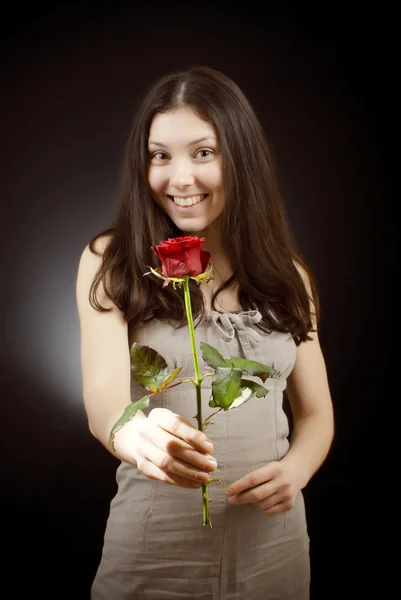 サラファンで美しい少女を与える赤いバラ — ストック写真