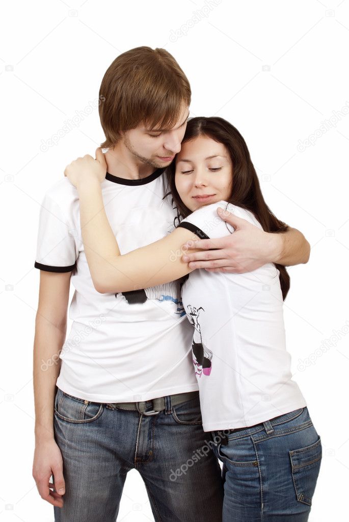 Pretty young couple tenderly embracing on a white background