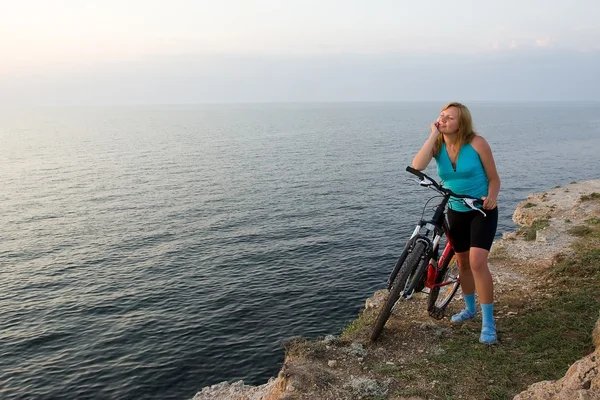 Flicka med cykel och havet. — Stockfoto