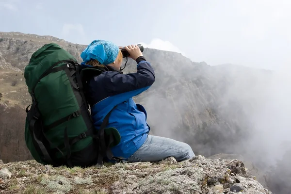 Dziewczyna w górach za pomocą jej lornetka. — Zdjęcie stockowe