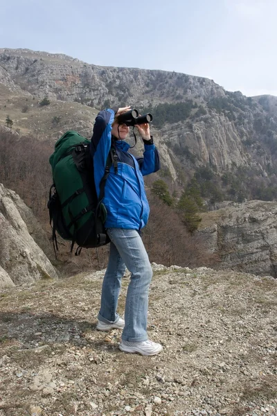 Menina com mochila está usando seu Binocular . — Fotografia de Stock