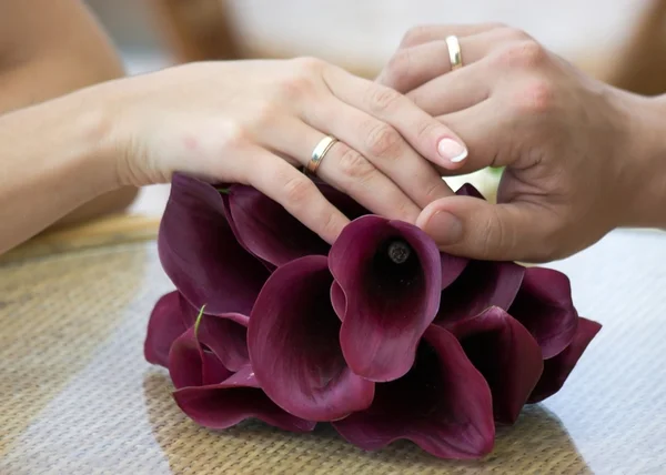 Mão do noivo e a noiva com alianças de casamento — Fotografia de Stock