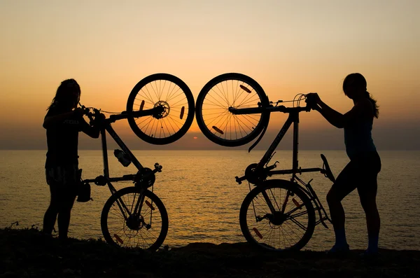 Couple with bikes watching sunset. — Stock Photo, Image