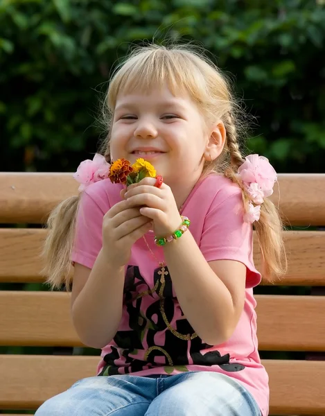 Mignonne petite fille avec des fleurs. — Photo