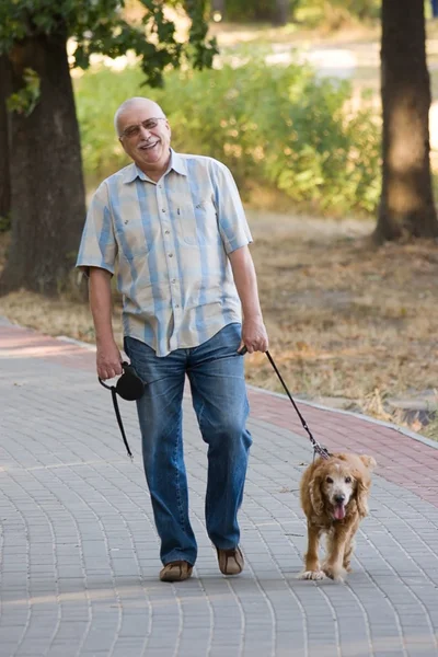अपने कुत्ते के साथ मुस्कुराते हुए पुराने सीनियर . रॉयल्टी फ़्री स्टॉक इमेज