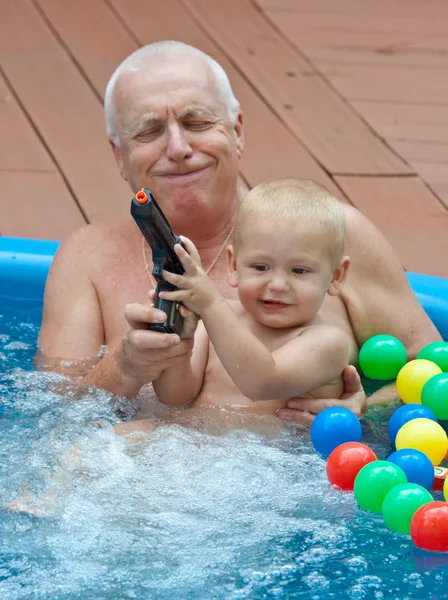 Dziadek i wnuczek, zabawy w basenie. — Zdjęcie stockowe
