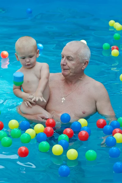 Dziadek i wnuczek, zabawy w basenie. — Zdjęcie stockowe