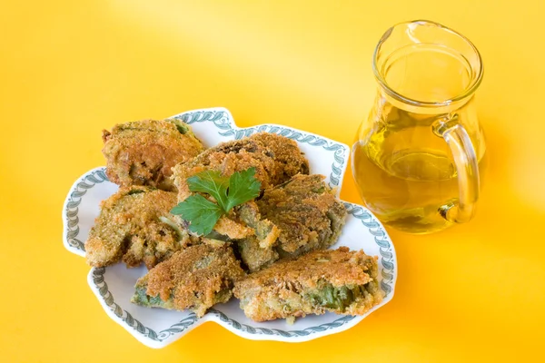 Bord met gefrituurde artisjokken en pot met olijfolie — Stockfoto