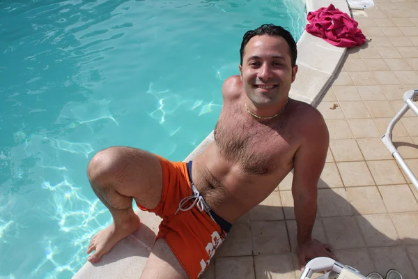 Levensstijlen Vrolijke Jonge Man Zit Het Bestuur Van Een Zwembad — Stockfoto