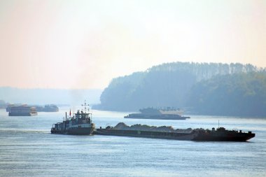 Silhouettes of cargo ships at the Danube clipart