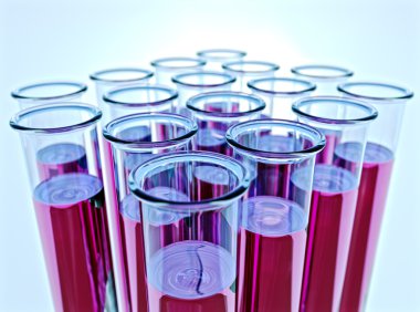 Sixteen test tubes with pink fluid and shallow DOF