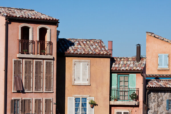 Colorful stucco buildings with windows . shutters and balconies