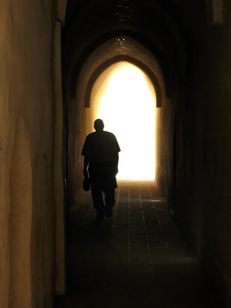 stock image Man walking at the end of a tunnel