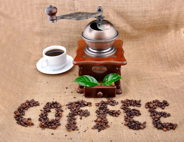 Vintage coffee grinder and sign coffe from coffee granules — Stock Photo, Image