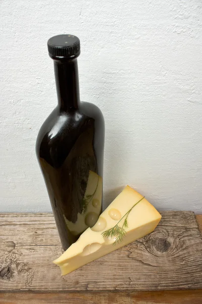 Bottle of wine and cheese on the background wall — Stock Photo, Image