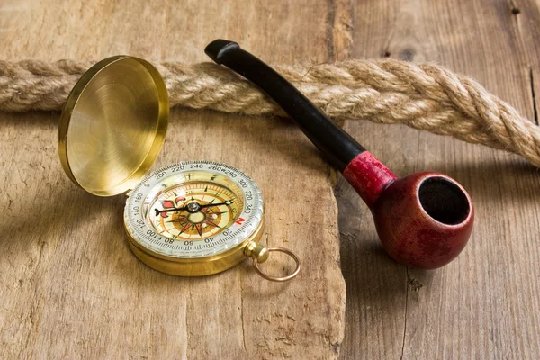 Compass and a pipe with a rope — Stock Photo, Image