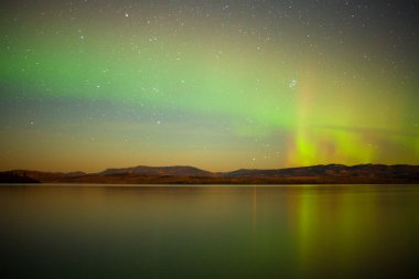 Northern lights mirrored on lake clipart