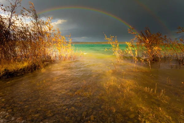Rainbow och mörka moln över stor sjö — Stockfoto